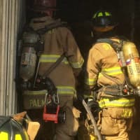 <p>Firefighters check the inside of the tractor-trailer.</p>