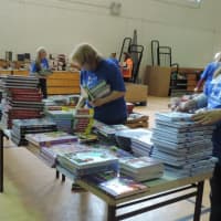 <p>Volunteers sort through the 40,000 books that will be distributed to students</p>