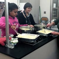 <p>Teacher Sharon Galletta spoons some mashed potatoes.</p>