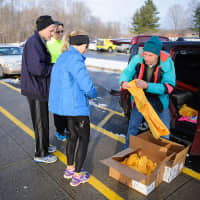 <p>Norwalk&#x27;s Jim Gerweck distributes t-shirts to runners at a Boston Buildup race in Ridgefield.</p>