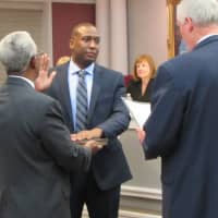 <p>New Fair Lawn Police Officer Brian Goodson is sworn in by Mayor John Cosgrove, while his father, Eugene, holds the Bible.</p>