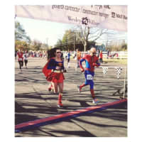 <p>Runners dressed as superheroes cross the finish line. Costumes are encouraged for the Village Halloween 5K &amp; Fun Walk in Shelton.</p>