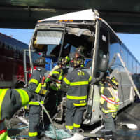 <p>Norwalk firefighters work to free the driver pinned inside the bus.</p>