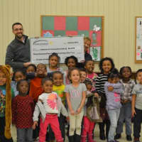 <p>Central Hudson&#x27;s Danick Fuller, standing at rear, presents a check to Betsy Kopster Stuts (standing rear right) who is chair of the Catherine Street Community Center, on Friday.</p>