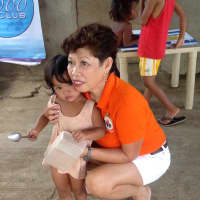 <p>Julie Cox hugs a little Filipino girl during one of her many food and medical missions to the Philippines.</p>