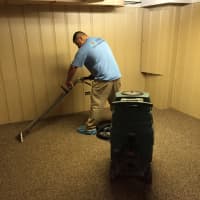 <p>AOA Cleaning and Restoration&#x27;s team removes water from the Kennedy family&#x27;s carpeting.</p>