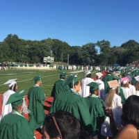 <p>The graduates stream onto the football field for the Norwalk High graduation.</p>