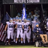 <p>Wayne Valley High School Co-Captain Jake Pluta carries the historic American flag onto the field.</p>