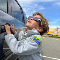 <p>A young member of the Lemus family watches the total solar eclipse, in perfect attire.</p>