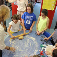 <p>Rolling out homemade dough, local children prepare homemade dog biscuits to give to homeless animals.</p>