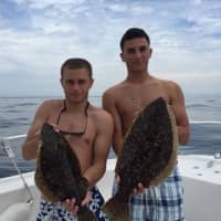 <p>Lucas Salem, right, and Brian Murphy show off a catch they pulled in at a fishing trip.</p>