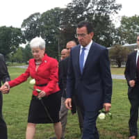 <p>Lt. Gov. Nancy Wyman and Gov. Dannel Malloy prepare to place flowers at the state memorial at Sherwood Island State Park in Westport.</p>