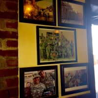 <p>Pictures of service men and women that received care packages hang on the wall</p>