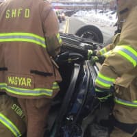 <p>Members of the Stony Hill Volunteer Fire Department attend to a rolled over car in Bethel just past noon Monday.</p>