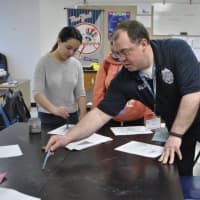 <p>Students learn how to dust for fingerprints and even take their own fingerprints under the direction of Danbury police officer David Antedomenico during a March 22 career fair at Rogers Park Middle School.</p>
