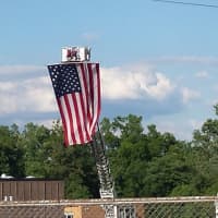 <p>The Nanuet Fire Department use one of their trucks to display an American flag in the background of the event.</p>