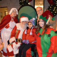 <p>Danbury Mayor Mark Boughton, top right, visits Santa, Mrs. Claus and an elf with a young fan at the tree lighting event at the library. </p>