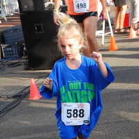 <p>A young girl runs in the All Out for Autism race.</p>