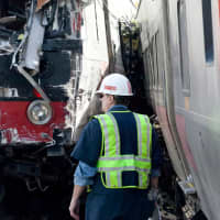 <p>National Transportation Safety Board workers inspect the damage at the site of the collision between two Metro North trains on the Bridgeport-Fairfield border.</p>