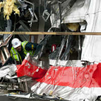 <p>A National Transportation Safety Board worker inspects one of the trains damaged in the collision last Friday on the Bridgeport-Fairfield border.</p>