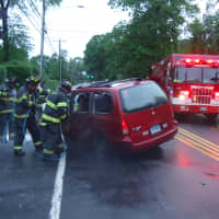 <p>Firefighters work to get the driver out of a minivan after a crash near 29 East Ave. </p>