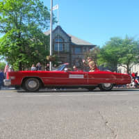 <p>The parade&#x27;s grand marshal, Leonard Fisher, a World War II veteran, waves from a convertible. </p>
