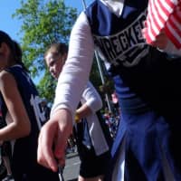 <p>Cheerleaders hand out flags along the parade route in Westport. </p>