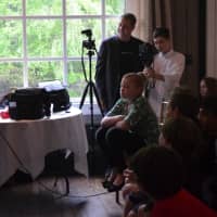 <p>Alexander Boston reads a speech before the premiere of his short film at Weston&#x27;s Cobb&#x27;s Mill Inn as one of the film&#x27;s stars, Colinn McGinniss, his father Johnny Boston and videographer Sam Theriault look on.</p>
