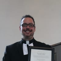 <p>Bronxville pastor Robert Hartwell raises his award in Mount Vernon.</p>