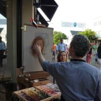 <p>Southbury-based artist Alain Picard creates a portrait of a woman Thursday on Main Street during the Art About Town street party.</p>
