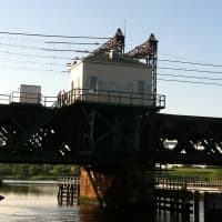 <p>Flag men are spotted on the stuck train drawbridge Friday evening over the Norwalk River.</p>
