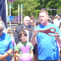 <p>Bill Lavin holds big scissors at the ribbon cutting for the new playground.</p>