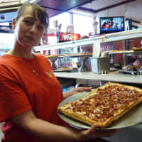 <p>A Pinocchio Pizza employee in Wilton shows off the pulled pork pizza, one of two special pies made during Tuesday&#x27;s A Slice for the Cure event.</p>
