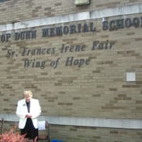 <p>Sister Frances Irene Fair stands in front of the new wing at Bishop Dunn school that was named after her.</p>