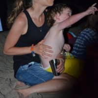 <p>A youngster reaches for the sky as he enjoys the Westport fireworks from a friendly lap. </p>