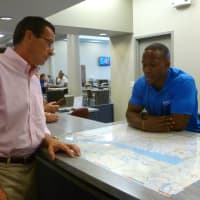 <p>Humza Abdul, a seasonal associate with the state&#x27;s cultural and tourism department, gives Gov. Dannel Malloy a rundown of attractions in the state at the Connecticut Tourism desk at the I-95 Welcome Center in Darien. </p>