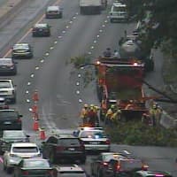<p>DOT crews work to cut up the tree and remove it from the highway at about 9:50 a.m. Thursday. Traffic is backed up for miles behind the cleanup scene.</p>