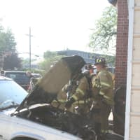 <p>Firefighters work to knock out a fire in a car in New Canaan. The blaze spread to the garage. </p>