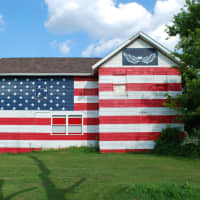 <p>A photograph of a house in Mich., painted to look like an American flag by Robert Carley. His exhibit, Flags Across America, is up at the Bruce Museum in Greenwich, Conn.</p>