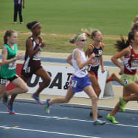 <p>Angela Saidman of the Wilton Running Club, in the blue shorts and white tank, runs with a pack of other runners at the national championships.</p>