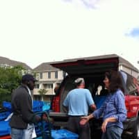 <p>Volunteers with Norwalk-based Community Plates make food deliveries in big blue bins.</p>