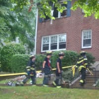 <p>Harrison firefighters head into the house on Underhill Avenue where a woman was killed in a fire early Tuesday.</p>