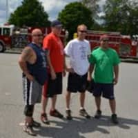 <p>Firefighters pose for a photo between charity games Saturday. </p>