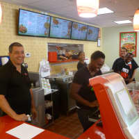 <p>Former Dobbs Ferry resident Justin Fiore. left, works with his crew at his new Planet Wings franchise in Ardsley.</p>