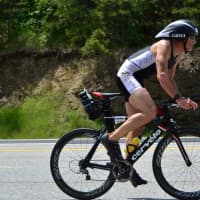 <p>Mike Christie, 57, pedals his bike in the Ironman race.</p>