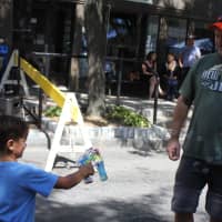 <p>Kevin Hart, of Ardsley, blows bubbles with his son at the Sleepy Hollow Street Fair.</p>