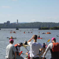 <p>Volunteers watch as participants get ready to enter the Hudson River.</p>