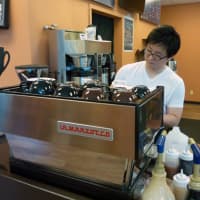 <p>Ridgefield resident Han Lee prepare a beverage at his coffee shop and cafe, Coffee Story, in Wilton. </p>