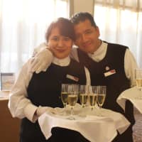 <p>Staff members happily serve champagne to guests for the grand opening.</p>