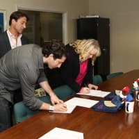 <p>Dr. Kathy Reilly Fallon, David Singer and Jonny Hirsch finish some paper work.</p>